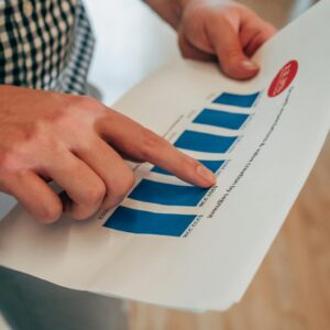 A Person Holding a Report with Chart Pointing on a  Number