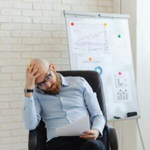 Man in Blue Long Sleeve Shirt Sitting on Black Office Chair