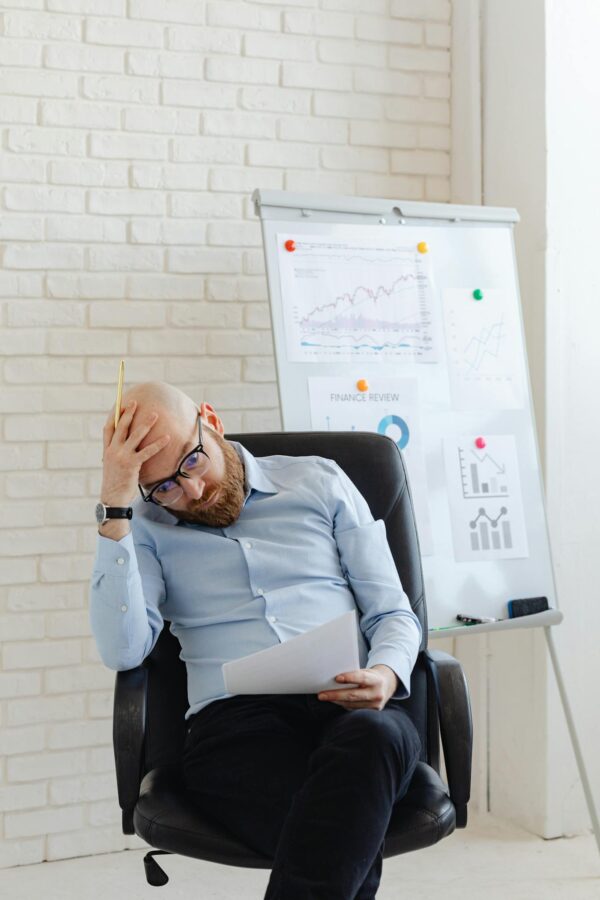 Man in Blue Long Sleeve Shirt Sitting on Black Office Chair